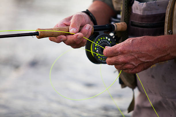 Elderly man fly fishing in a river An elderly man flyfishing on the Beaver River in Heathcote, Ontario, Canada. officer boots stock pictures, royalty-free photos & images