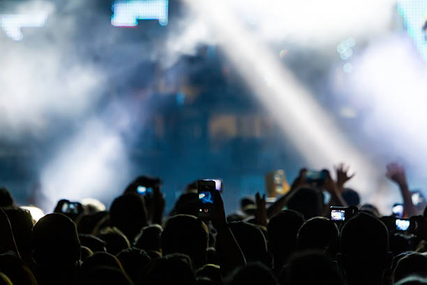 istock People taking photographs with touch smart phone during a music 501824998