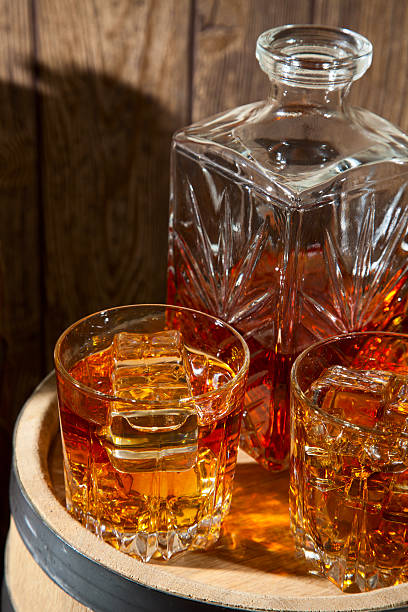 istock Two glasses of whiskey with ice and decanter 501827400