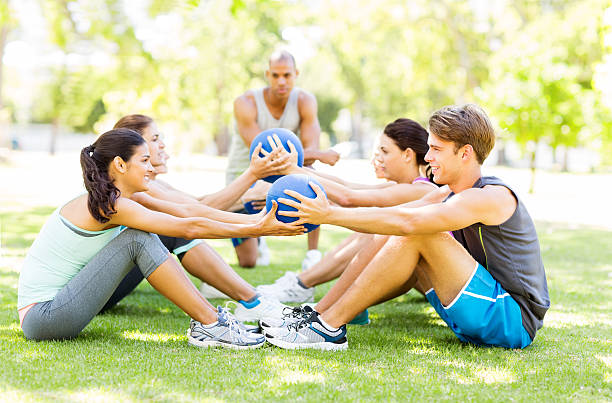 istock Bootcamp Trainer Looking At People Exercising With Medicine Ball 501832493