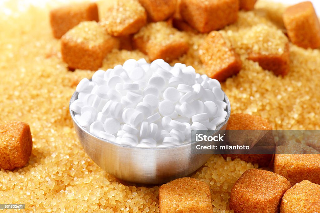 sugar and sweetener cane sugar and bowl of sweetener pills Artificial Stock Photo