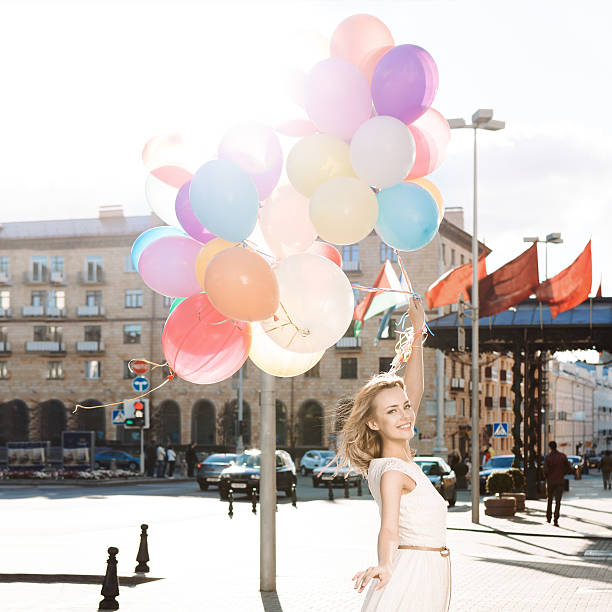 istock beautiful lady holding a bunch of balloons 501833995