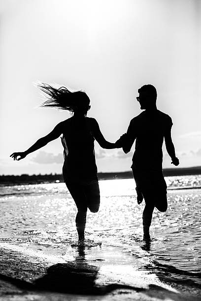 istock Silhouette Of Young Couple Running 501834625