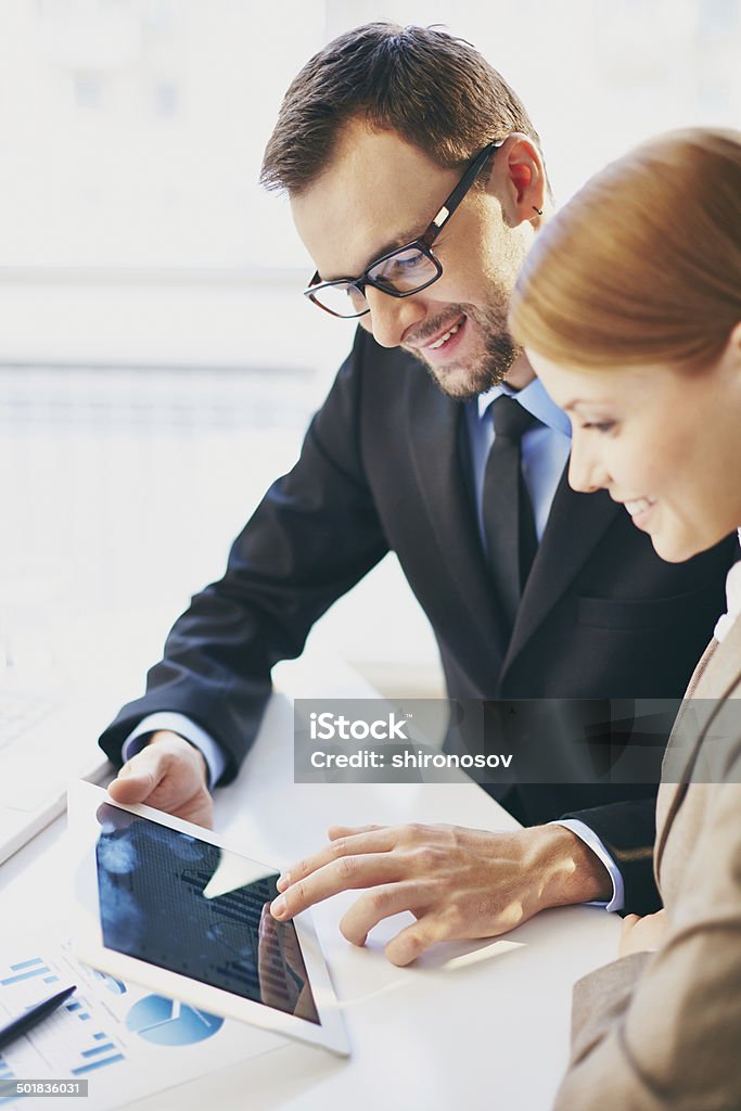 Networking Young businessman and his colleague using touchpad at meeting Business Meeting Stock Photo