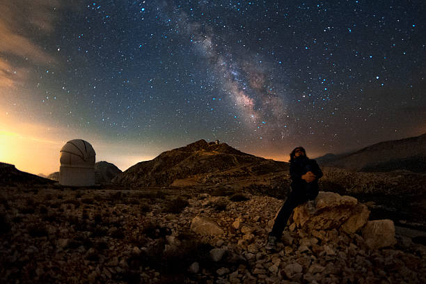 The milky way and the observer An astronomer is enjoying a starry night under the milky way. hubble space telescope photos stock pictures, royalty-free photos & images