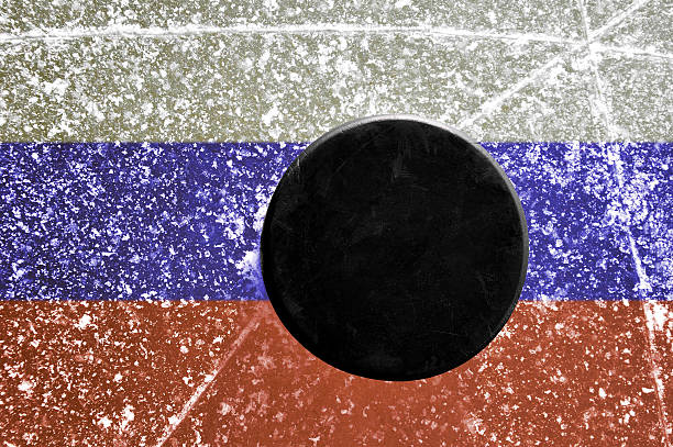 istock Black hockey puck on ice rink 501844254