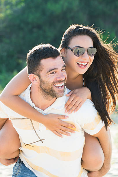istock Young couple having fun in piggyback ride at the beach 501845110