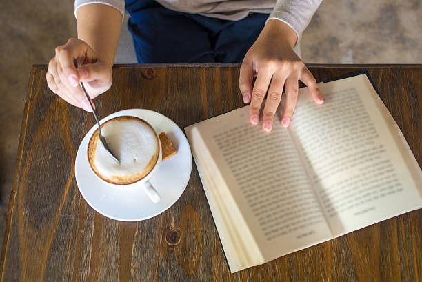 Enjoy a free day with book and cup of cappuccino stock photo