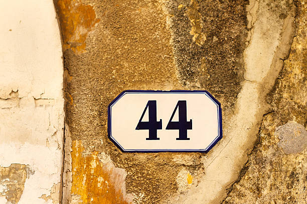 istock Number 44 Street Address Tile On Old Yellow-Orange Wall 501847134