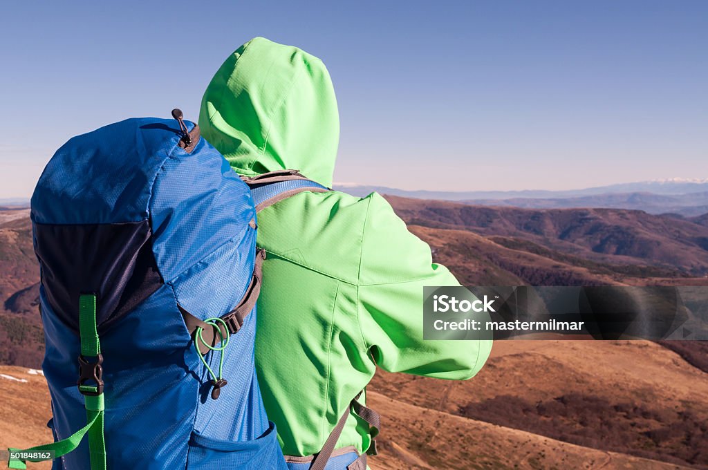 Hiker looking at the mountain scenery Hiker looking at the mountain scenery from the top 2015 Stock Photo