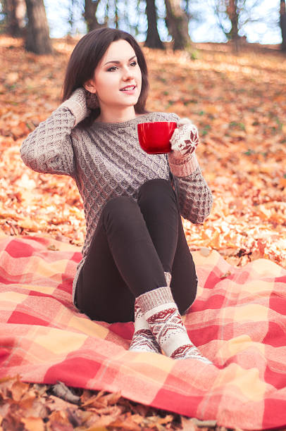 istock Young woman sitting on ug and holding a big cup 501849928