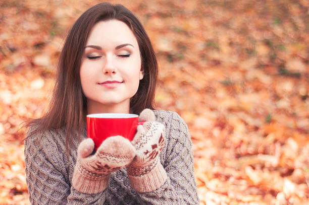 istock Young woman holding a big red cup and smelling tea 501849970