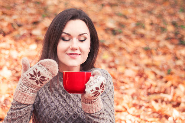 istock Young woman holding a big red cup and smelling tea 501849986
