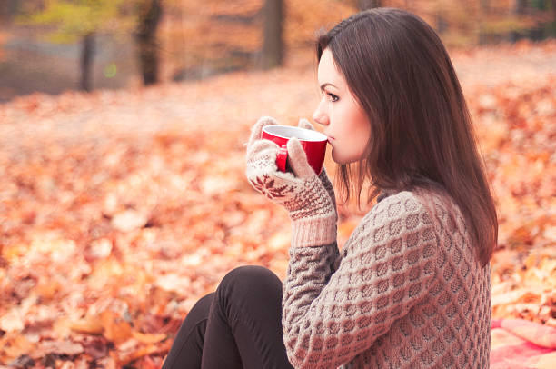 istock Young woman sitting in a park and drinking tea 501850214
