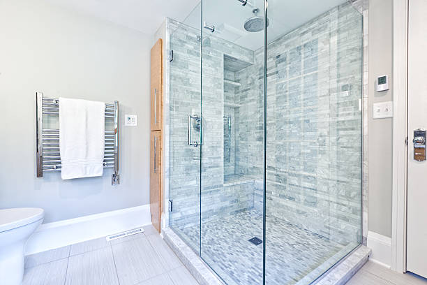 contemporary home bathroom glass shower stall with marble tiles - douchen stockfoto's en -beelden