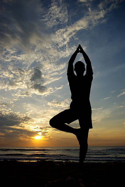 istock Young man doing yoga in beach 501851510