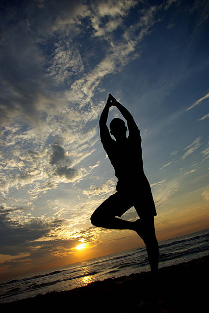 istock Young man doing yoga in beach 501851572