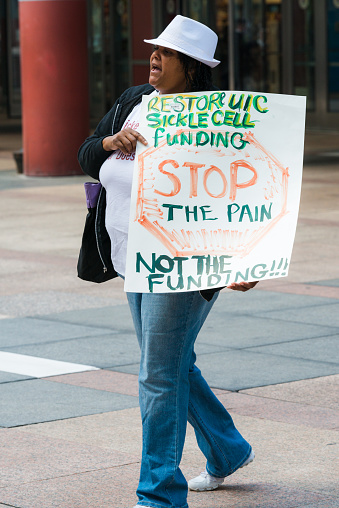 Chicago, USA - September 10, 2015: A woman protesting to raise awareness outside the James R Thompson Center in downtown for Sickle Cell funding late in the day.