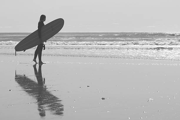 istock Surfergirl with longboard on the beach 501851884