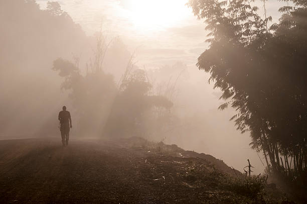 ��男性のお客様のトレッキングの日の出霧のかかった森のミャンマーで - footpath single lane road sunrise landscape ストックフォトと画像
