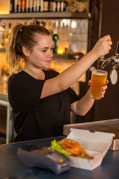 Barmaid Pouring a Beer in a Bar