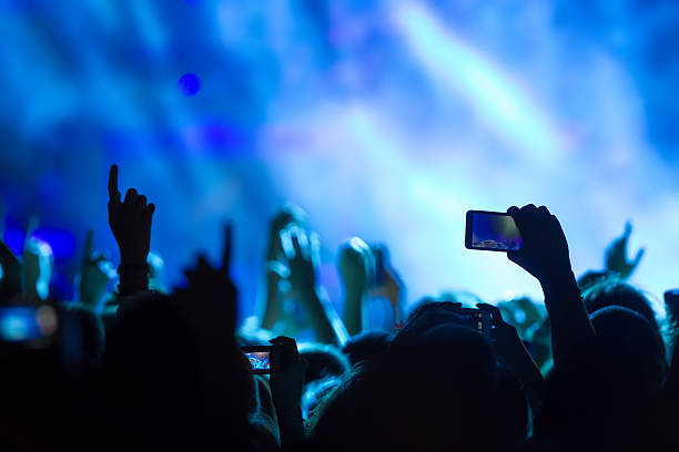 istock People taking photographs with touch smart phone during a music 501858116