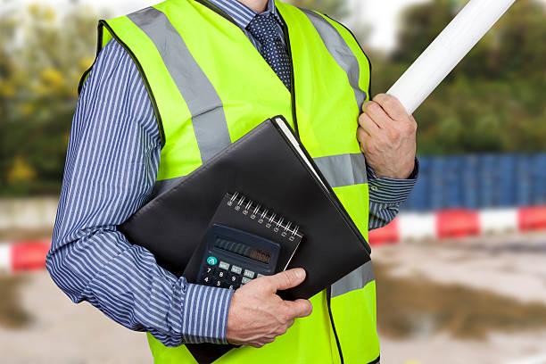 istock Building surveyor in hi vis carrying work folders and calculator 501858206
