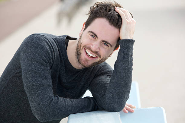 Handsome man smiling with hand in hair