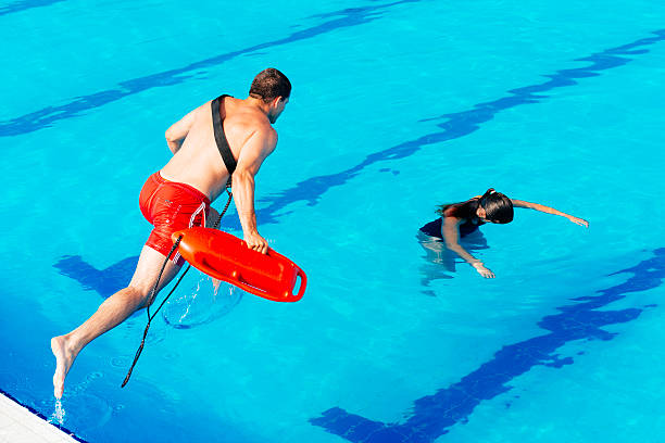 bagnino in azione - lifeguard swimming pool summer swimming foto e immagini stock