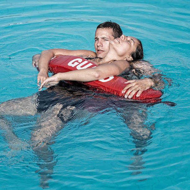 salvavidas rescuing víctima de agua - floating on water swimming pool men water fotografías e imágenes de stock