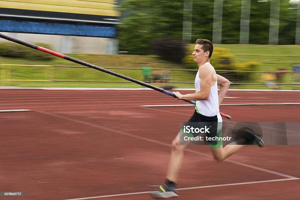 Side View of Young Male Athlete at Pole Vault Competition Young male athlete running before a jump, blurred motion Pole Vault Stock Photo