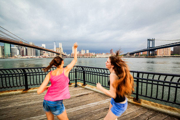 istock Two girls, sisters, looking to Manhattan under thunderstorm 501861263