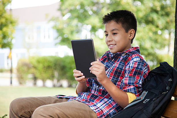 Cheerful boy reading a tablet stock photo