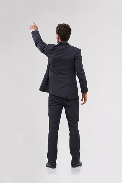 The only way forward is with technology Rear view of a handsome young businessman touching a transparent digital interfacehttp://195.154.178.81/DATA/i_collage/pi/shoots/783507.jpg rear view stock pictures, royalty-free photos & images
