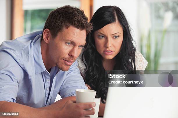 Worried Couple Looking At Laptop Computer Stock Photo - Download Image Now - 20-24 Years, 20-29 Years, 30-34 Years