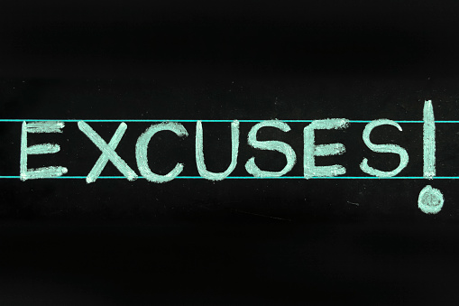 excuses word handwritten on black chalkboard
