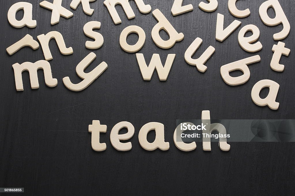 Teach in Wooden Letters Wooden letters spell the word teach on a blackboard  Alphabet Stock Photo