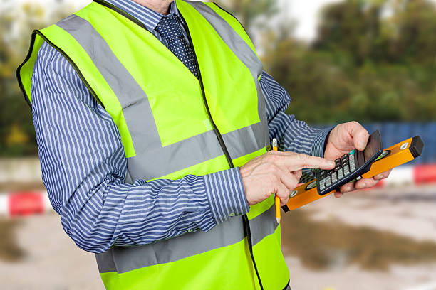 istock Building surveyor in hi vis vest with calculator 501878932