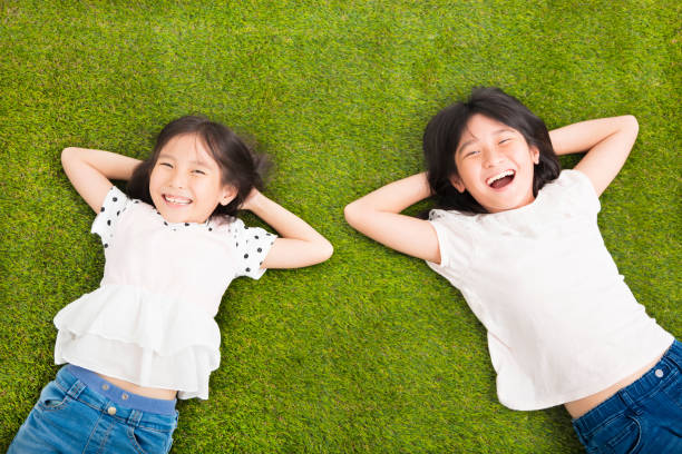 istock happy Little  girls resting on the grass 501880366