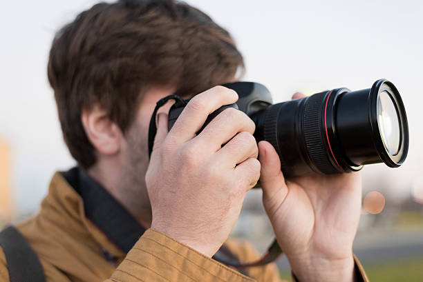 istock male photographer taking photos 501884736