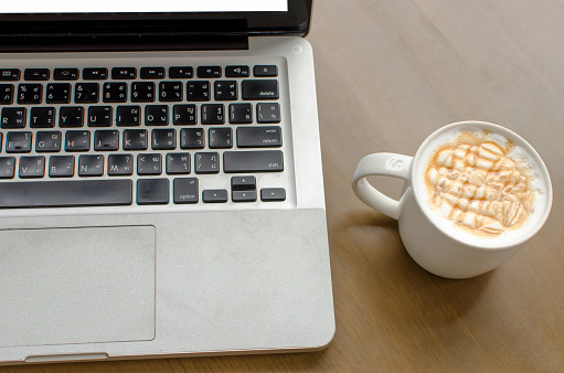 Coffee cup , laptop in coffee shop