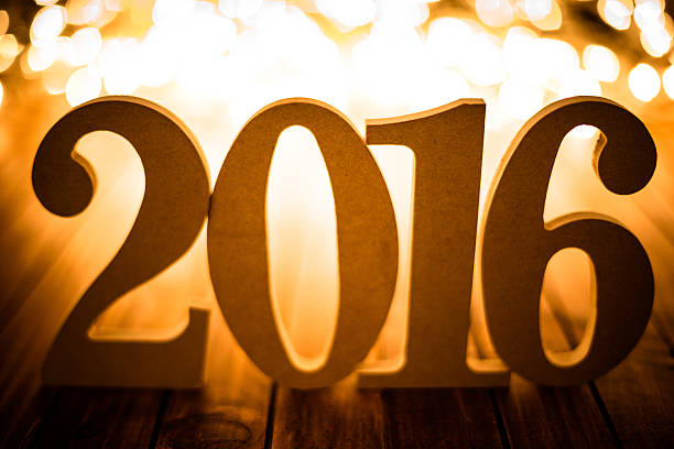 istock christmas light and 2016 New year text on plank wood 501894116