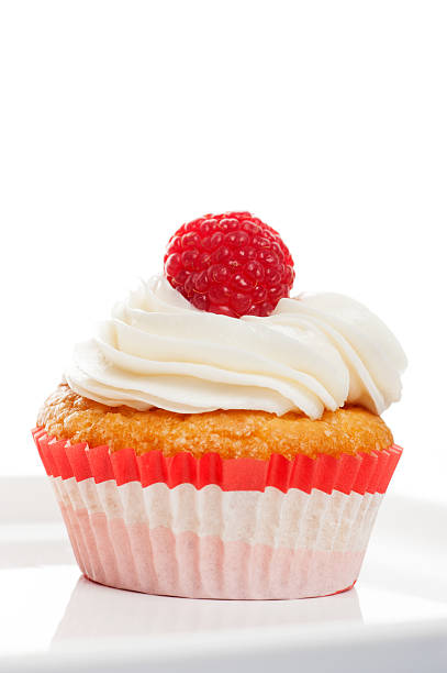 istock Vanilla Cupcakes with cream and a red berry on top 501906230