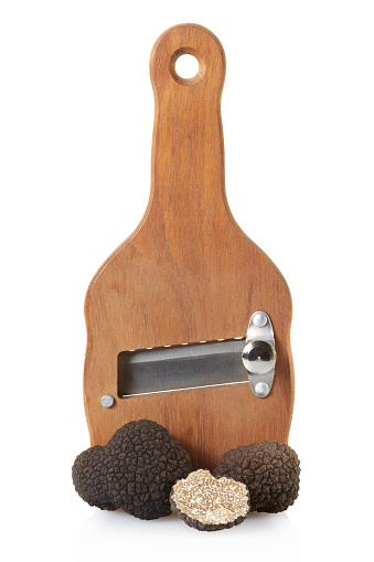 Black truffles and wooden truffle slicer isolated on white, clipping path included