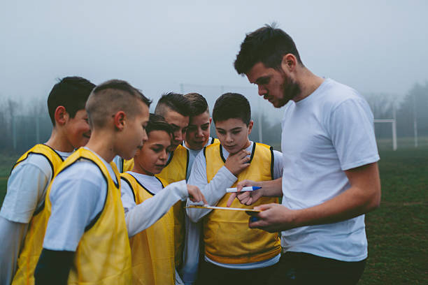 istock Coach Giving Instruction To His Kids Soccer Team. 501908786
