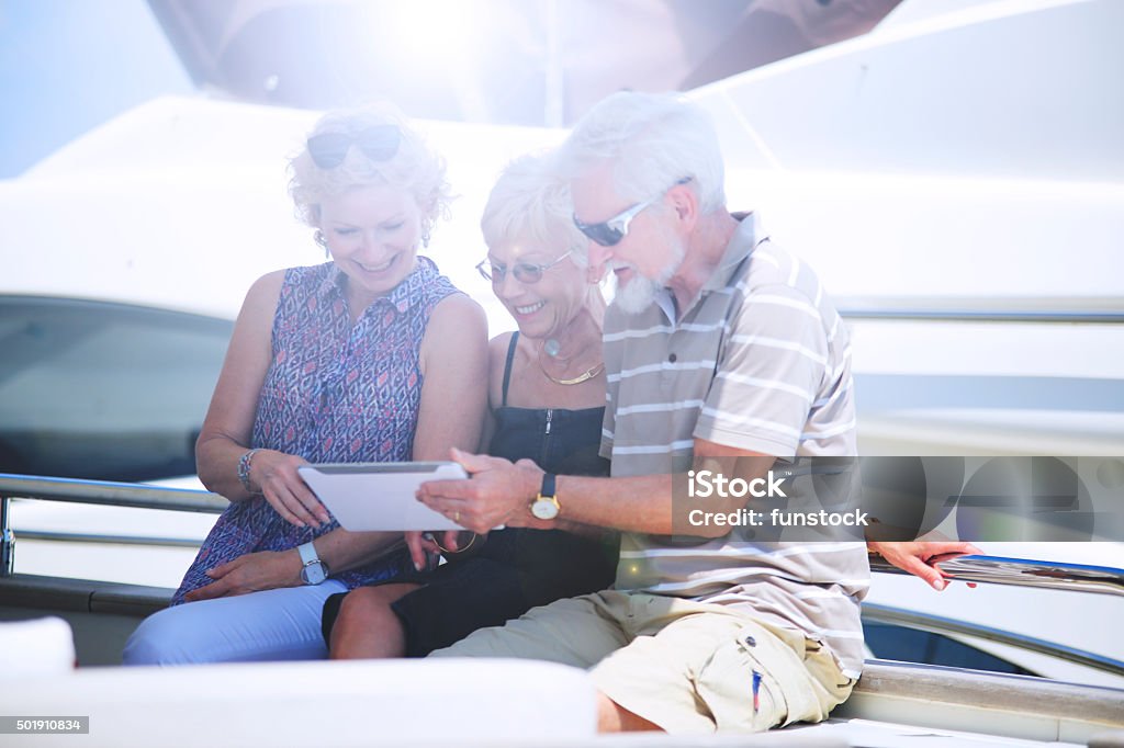 Seniors on vacation on Yacht using digital tablet Active Seniors Stock Photo