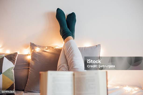 Mujer Relajante En Una Mala Y Leer Un Libro Foto de stock y más banco de imágenes de Leer - Leer, Invierno, Adolescente