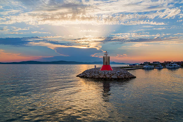 istock Beautiful lighthouse by the ocean at sunset 501914374