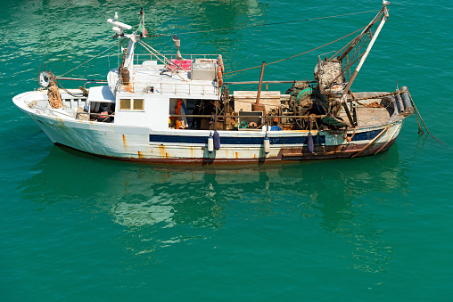 Old trawler fishing boat with fishing equipment docked in port - Lerici, La Spezia, Liguria, Italy