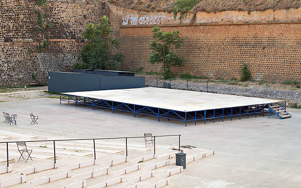 Empty seats audience area outdoor theater long wooden benches city park umbrella. High quality photo